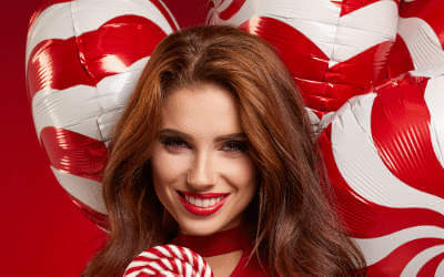 A woman with a bunch of candy striped balloons